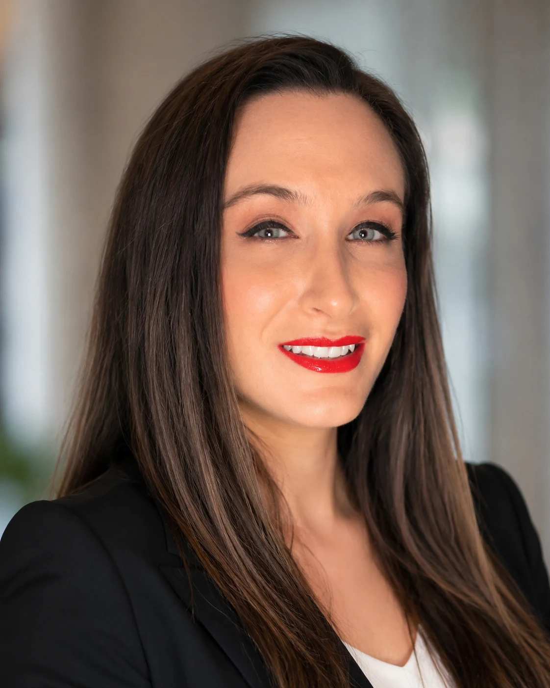 Jess, founder of Surviving With Sav, smiling, with long dark hair and red lipstick